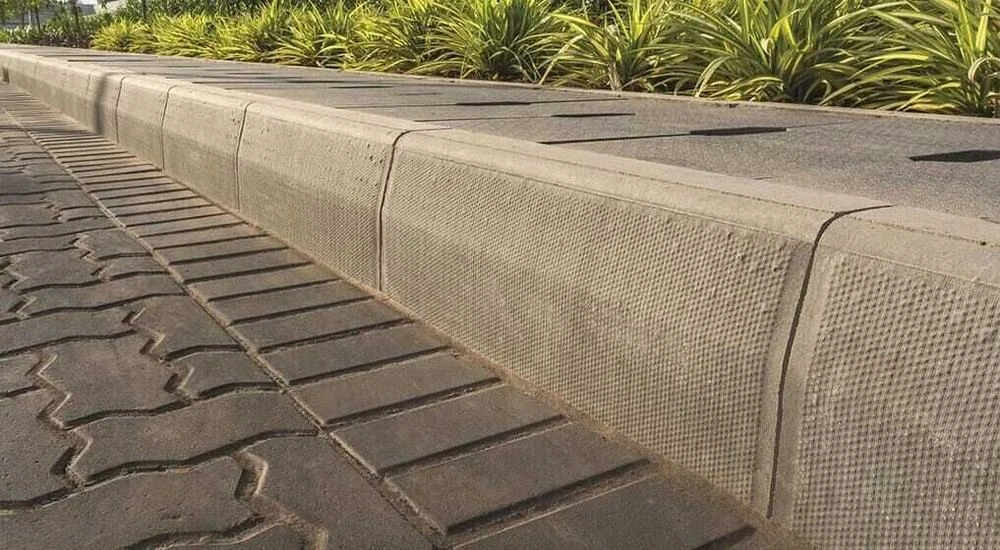 Textured kerbstone edging a zigzag paver walkway