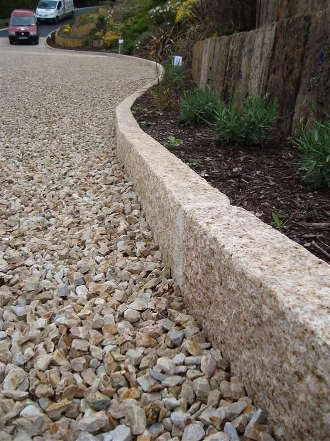 Kerbstone edging a gravel driveway
